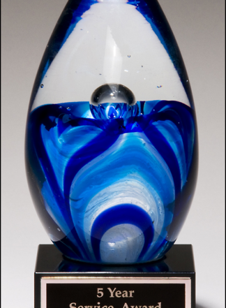 Art glass egg with blue and white accents on black glass base